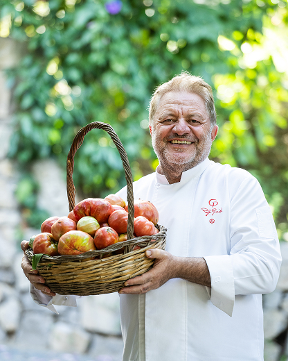Lo chef con una cesta di pomodori
